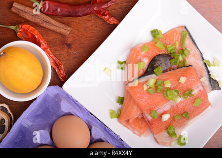 fresh salmon fillet on white plate. red pepper, cinnamon and lemon Stock Photo