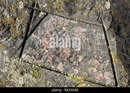 Natural and polished surface of a boulder of Filipstad Granite, close-up Stock Photo