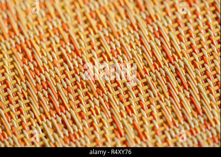 Warm colors of orange, red and yellow in an abstract woven background. Stock Photo