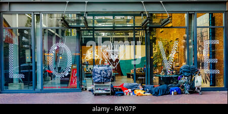 Homeless person sleeps in front of Fluevog Shoes store front, Gastown, Vancouver, British Columbia, Canada Stock Photo