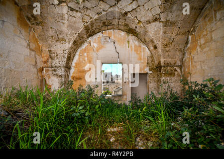 A window in an ancient wall in the prehistoric city of Matera in the Basilicata region of Southern Italy. Stock Photo