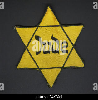 Jewish Star on display at the Czech-Slovak Exhibition (Česko-slovenská výstava) in the National Museum (Národní muzeum) in Prague, Czech Republic. All inhabitants of the Protectorate of Bohemia and Moravia who had been considered like Jews by Nuremberg Laws (Nürnberger Gesetze) was signed those cloth badges after 1939. The exhibition devoted to the centenary of Czechoslovakia which runs till 30 June 2019. Stock Photo