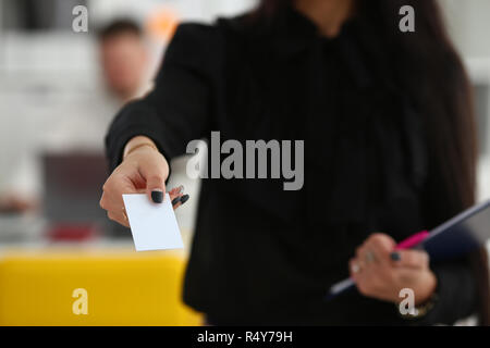 Female arm give blank calling card to visitor Stock Photo