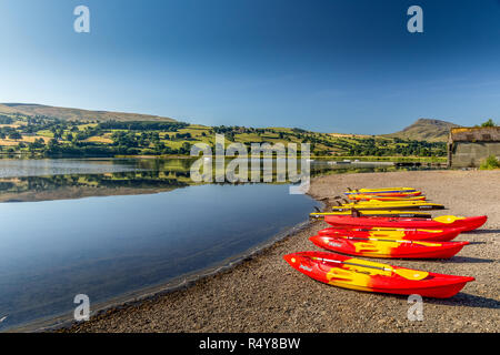 Lake Bala, or Llyn Tegid in Gwynedd, mid Wales, UK. Known for its attraction for watersports, a line of kayaks on the shoreline. Stock Photo