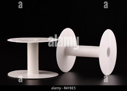 Two plastic empty spools of lace on a black background Stock Photo