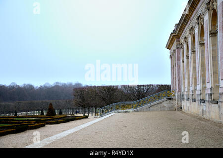 Palace of Versailles. Gliding and blue stairs, palace with columns, view on the garden with symmetry and geometric features Stock Photo