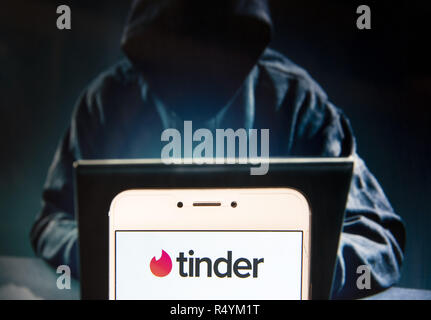 Hong Kong, China. 23rd Nov, 2018. Mobile dating app Tinder logo is seen on an Android mobile device with a figure of hacker in the background. Credit: Miguel Candela/SOPA Images/ZUMA Wire/Alamy Live News Stock Photo