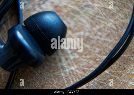 Close-up headphone stack on table, modern smartphone's earbuds device accessories. Stock Photo