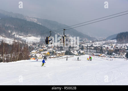 Szczyrk, Poland - February 26, 2018: People skiing at Szczyrk Mountain Resort, with a new 10-seat gondola lift and artificially snow-covered and illum Stock Photo