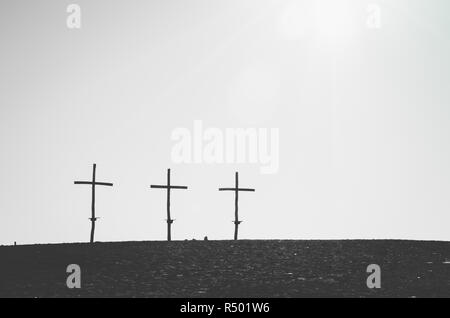 Three similar crosses on the horizont line in black and white Stock Photo