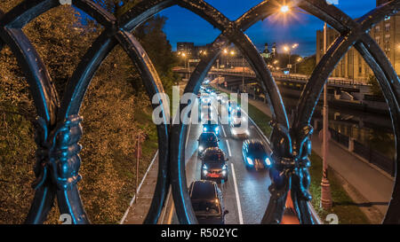 shot of the night traffic made through a cast-iron fence Stock Photo