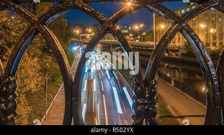 night traffic made through a cast-iron fence Stock Photo