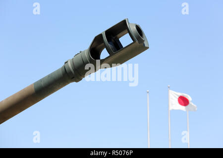 Japanese military cannon with japanese flag against a blue sky Stock Photo