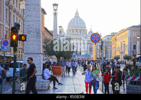 ROME, Italy - October 13, 2018: Crowds of people walk near the St Peter's Basilica at the sunset in Rome, Italy. St Peter's cathedral in Vatican City  Stock Photo