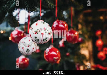 Close up of red and white Christmas tree decorations on sale at a European Christmas market.