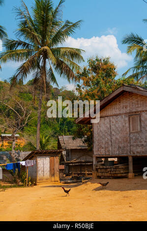 Traditional  Lao rural village houses made of wood, and woven split bamboo walls and built on wooden stilts between Huay Xai and Pakbeng, Laos, Lao Stock Photo