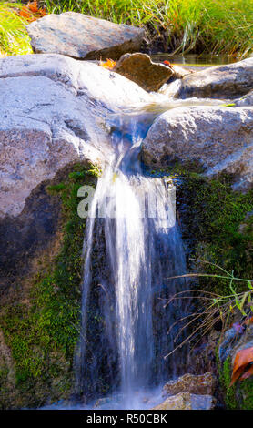 Small waterfall in the red mountains. Gryz village. Guba region ...