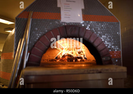 Fire in dome ceramic wood burning pizza oven at Amsterdam Brewhouse Toronto Stock Photo