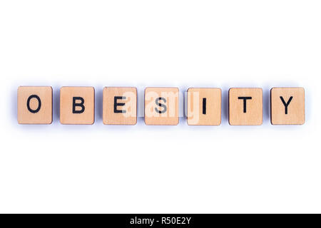 The word OBESITY, spelt with wooden letter Scrabble tiles. Stock Photo