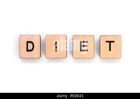 The word DIET - spelt with wooden letter tiles over a white background. Stock Photo