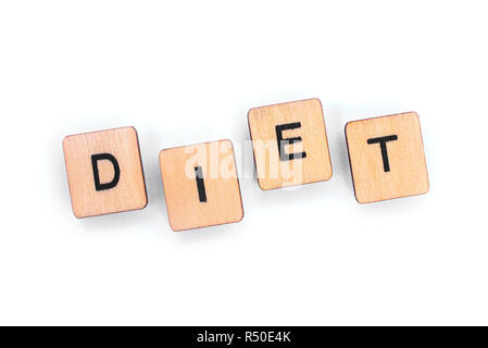 The word DIET - spelt with wooden letter tiles over a white background. Stock Photo