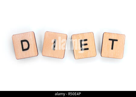 The word DIET - spelt with wooden letter tiles over a white background. Stock Photo