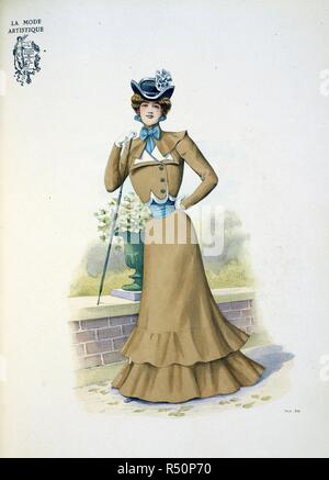 Design by Fred. A bolero and skirt; an autumn walking dress. It is made of fine faced cloth in a new tint which he has called 'fauvette' The skirt has two flounces cut en forme. The bolero has a collar and double revers of white.: it ends in rounded points above the waist, each one cut a little shorter than its fellow and overlaid. It is fastened by three large turquoise buttons down the left side. The belt, the vest and the cravate are all of turquoise blue. The three-cornered black felt hat is edged with a line of felt in white and trimmed on one side with a large chou of ribbon. . The Powde Stock Photo