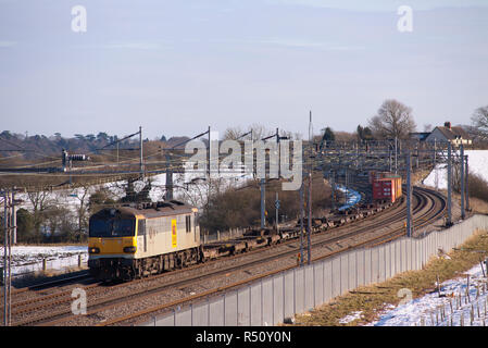 A class 92 electric locomotive number 92015 working a sparsely loaded down intermodal at a freezing and snowy Soulbury in Buckinghamshire. Stock Photo