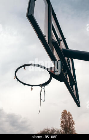 Street ball basketball board with torn net in urban surrounding Stock Photo