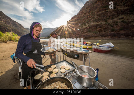 Two rafting guides cooking a meal at camp while on a Green river rafting trip, Â Desolation/GrayÂ Canyon section, Utah, USA Stock Photo