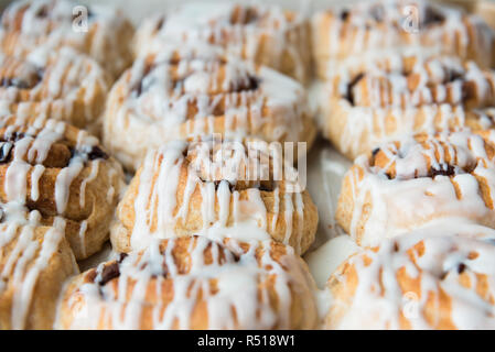 Full-frame freshly frosted cinnamon rolls in pan close-up Stock Photo