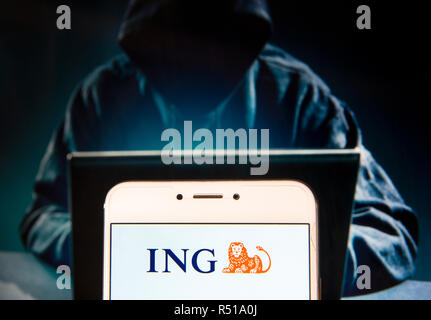 Dutch multinational banking and financial services company ING Group logo is seen on an Android mobile device with a figure of hacker in the background. Stock Photo