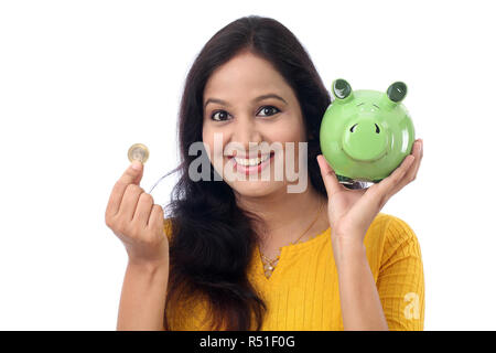 Young Indian Woman Saves Money in Piggy bank Stock Photo