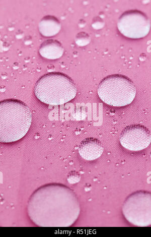 large drops of water on the water-repellent surface of the material used in the umbrella, close-up Stock Photo