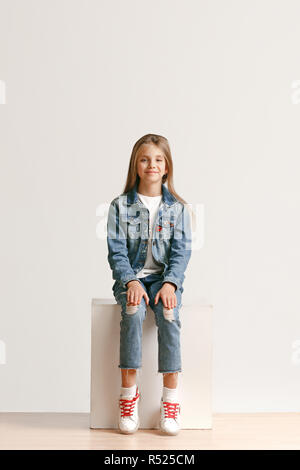 Full length portrait of cute little teen girl in stylish jeans