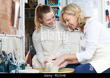 Mature Woman With Teacher In Pottery Class Stock Photo