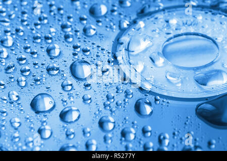 Water droplets on compact disc toned in blue color. Macro Stock Photo