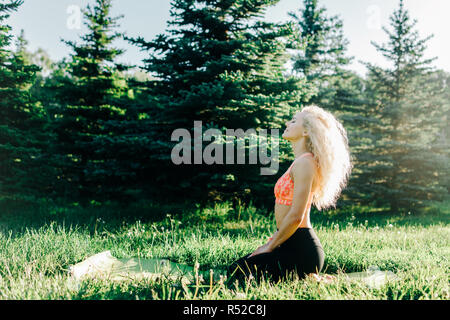 Image of young curly-haired sports woman practicing yoga on rug  Stock Photo
