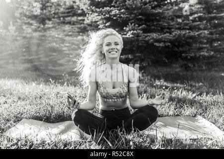 Image of young curly-haired sports woman practicing yoga on rug  Stock Photo