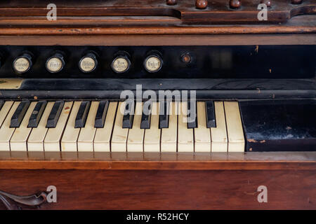 Close up of antique pump organ with sound buttons and piano keyboard. Interior of Texan home, Chestnut Square Historic Village, McKinney, Texas. Stock Photo