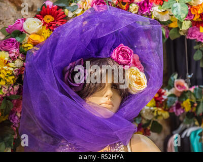 Istanbul, Turkey, June 17, 2014: Model in a shop window wearing a purple scarf and flowers. Stock Photo