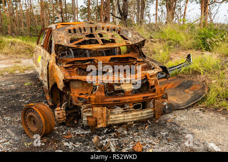 A burnt out car left to rot in the coutryside, just another one of many social issues around the world. Stock Photo