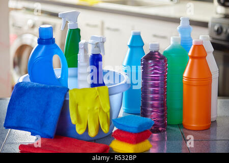 Household cleaning items in basket on kitchen table with blurred background Stock Photo