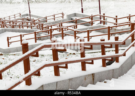 concrete steps and metal rails covered with snow in the winter season , phtography is made close-up Stock Photo