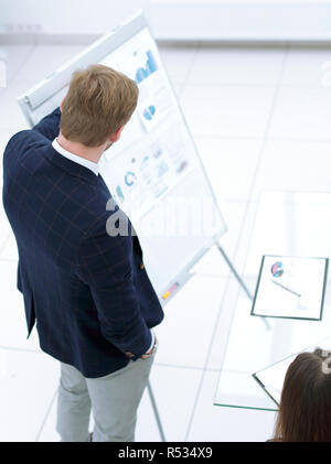 Businessman giving flipchart presentation explaining idea to diverse partners Stock Photo