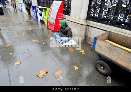 Homeless man outside Charing Cross Station, Strand, London, England, UK. Wet day in November Stock Photo