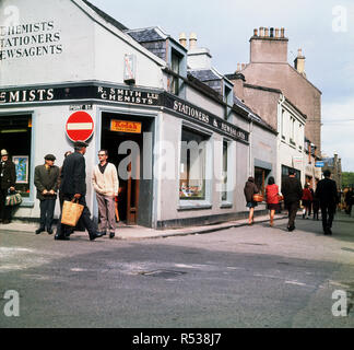1960s, historical, daytime and local people outside a shop of R. Smith Ltd, Chemists, Stationers and newsagents in Stornoway, Lewis, Isle of Lewis and Harris, Outer Hebrides, Western Isles, Scotland, UK. Stock Photo