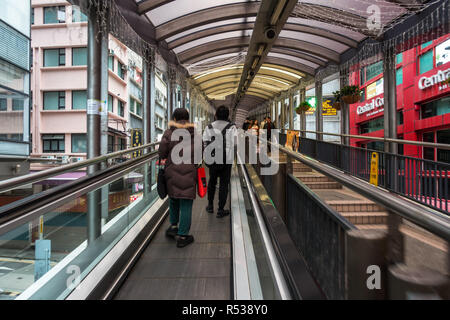 People walking on Central–Mid-Levels escalator, the longest outdoor covered escalator system in the world. Hong Kong, Soho, January 2018 Stock Photo
