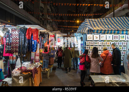 Local people shopping between the stalls at Temple Street Night Market. Hong Kong, Kowloon, Yau Ma Tei, January 2018 Stock Photo