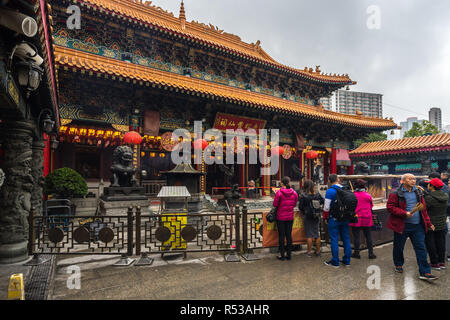 People offering incense at the main altar at Sik Sik Yuen Wong Tai Sin temple. Hong Kong, Kowloon, January 2018 Stock Photo